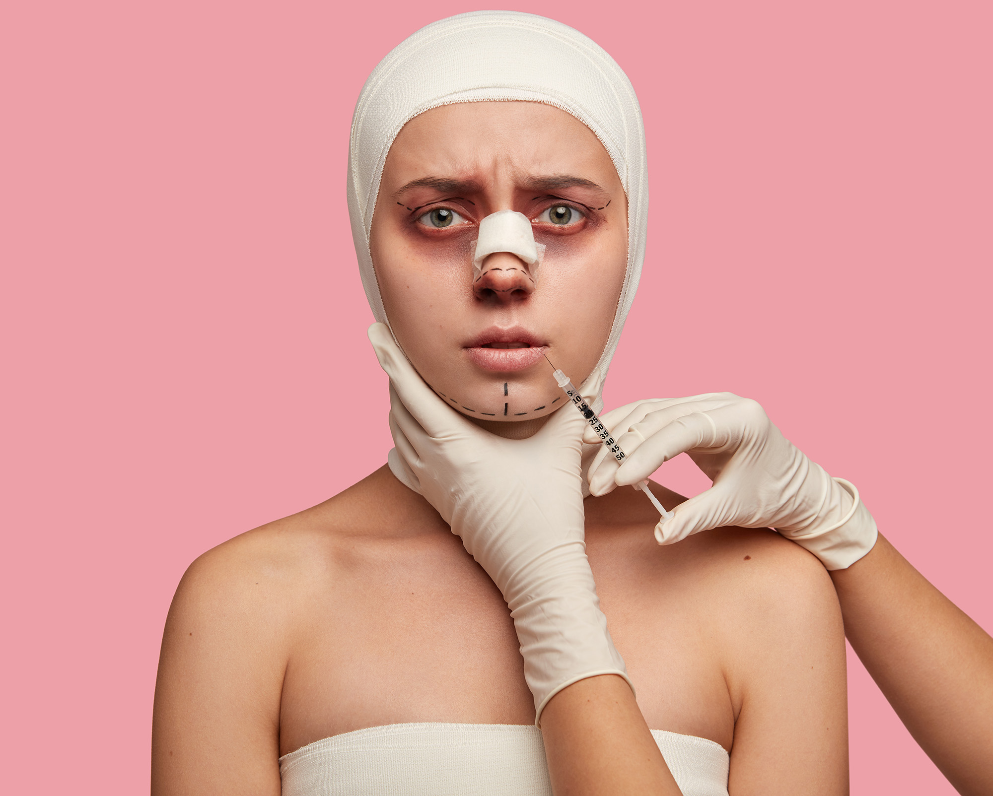 Mentoplasty and lip plumping concept. Young girl recieves cosmetic injection for lip augmentation, has bandage on nose after rhinoplasty, good medical treatment. Surgeon holds syringe near face